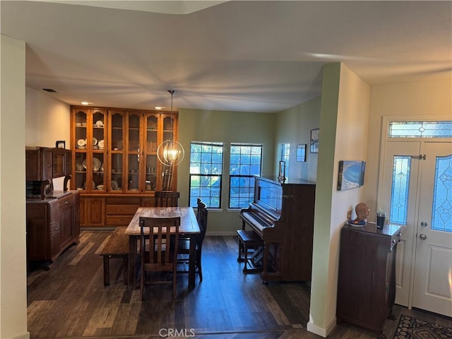 dining room with baseboards, a chandelier, and dark wood-style flooring