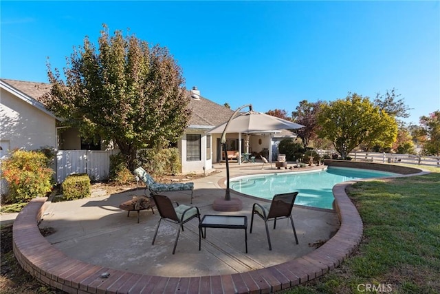 view of pool featuring a yard, a patio area, fence, and a fenced in pool