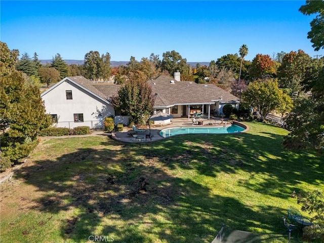 back of house with a patio, an outdoor pool, fence, a lawn, and stucco siding