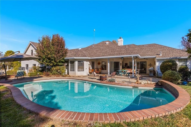 outdoor pool with a patio area and ceiling fan