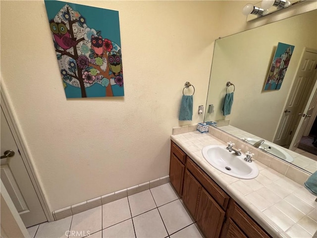 bathroom with tile patterned flooring, vanity, and baseboards