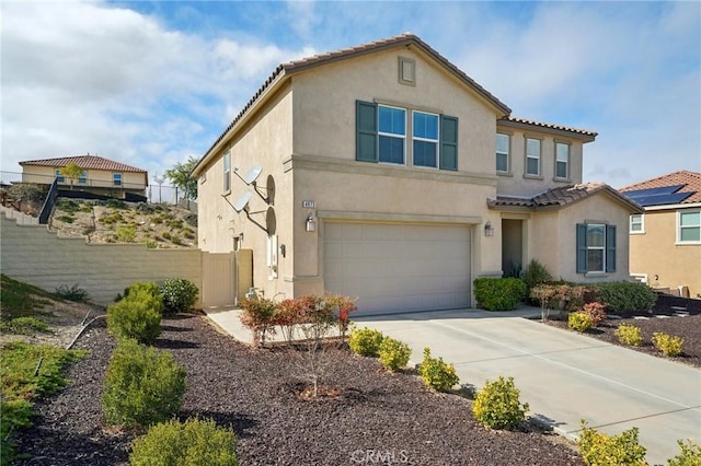 mediterranean / spanish home featuring a garage, driveway, a tiled roof, and stucco siding