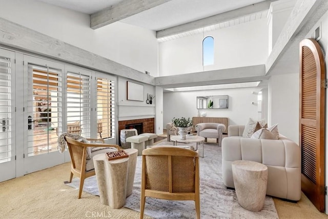 carpeted living room with a brick fireplace, a towering ceiling, and beamed ceiling