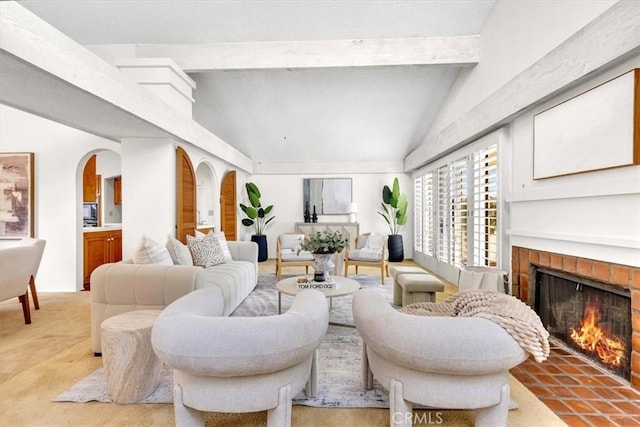 living room with a fireplace, light carpet, and vaulted ceiling with beams