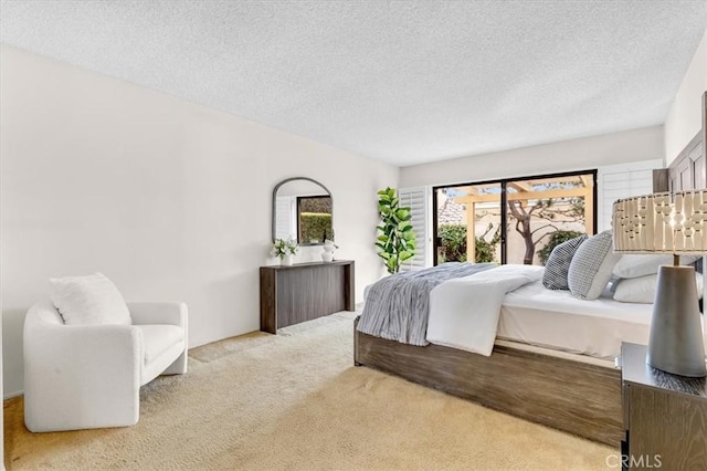 bedroom with light colored carpet and a textured ceiling