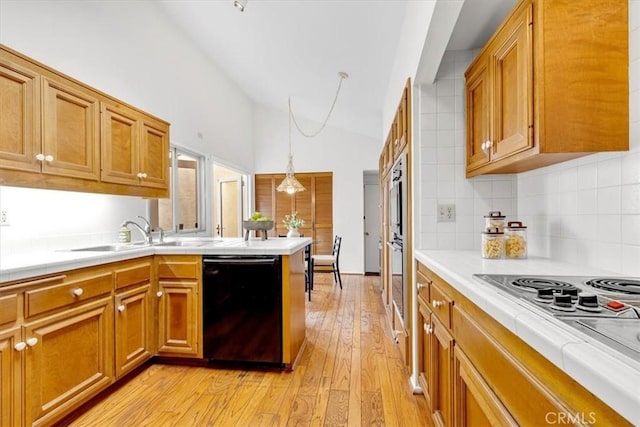 kitchen with white electric cooktop, tasteful backsplash, dishwasher, hanging light fixtures, and light wood-type flooring