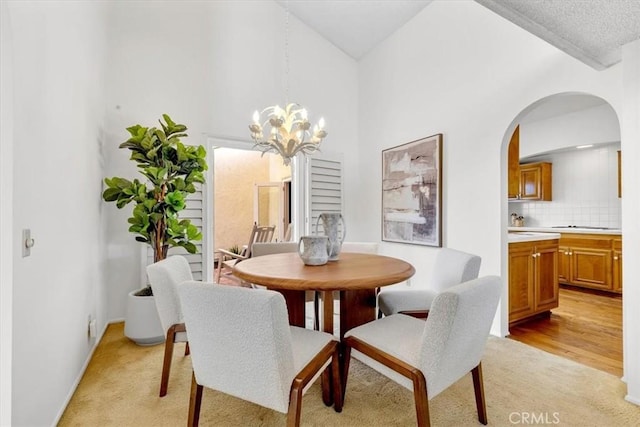 dining room with light carpet and a chandelier