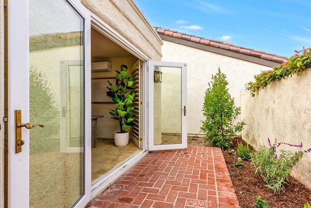 doorway to property with a patio and an AC wall unit