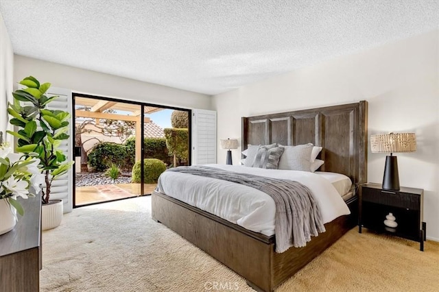 carpeted bedroom featuring access to exterior and a textured ceiling