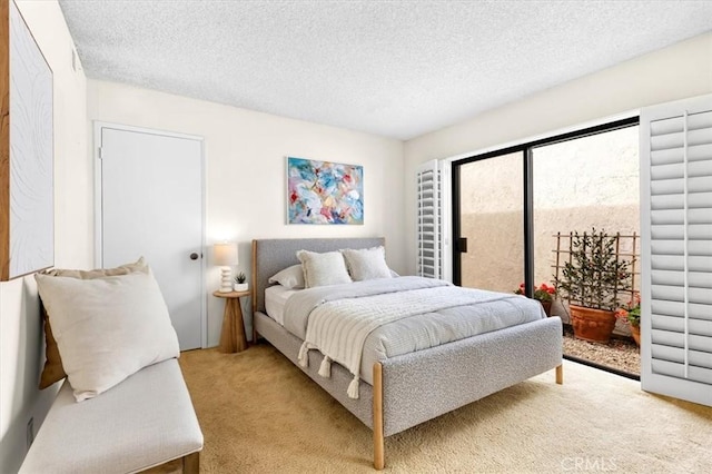 carpeted bedroom featuring access to outside and a textured ceiling