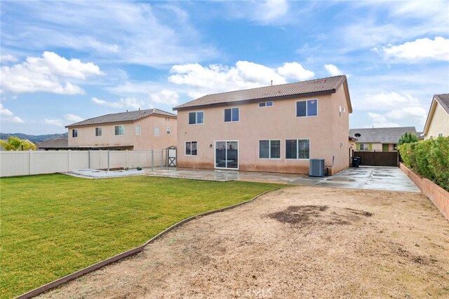 back of property with cooling unit, a lawn, and a patio