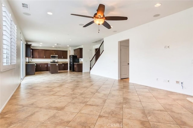 unfurnished living room with light tile patterned floors and ceiling fan