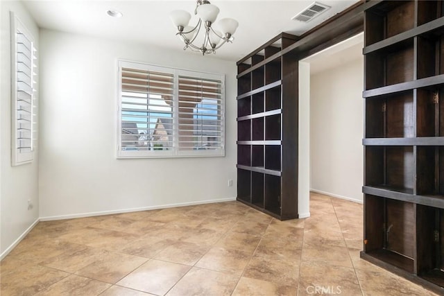 spare room featuring light tile patterned flooring and a notable chandelier