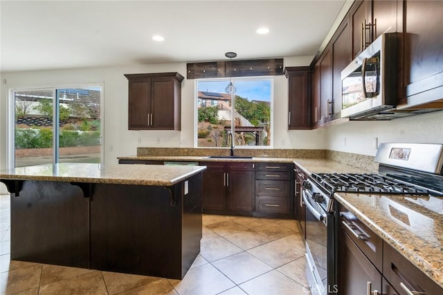 kitchen with pendant lighting, sink, a breakfast bar area, stainless steel appliances, and light stone countertops