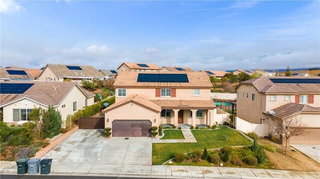 view of front of home with a front yard and solar panels