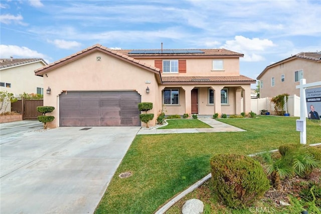 mediterranean / spanish-style house featuring a garage, a front yard, covered porch, and solar panels