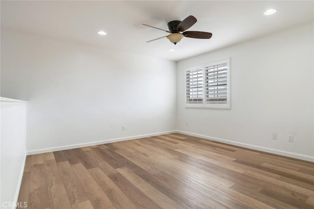 spare room with ceiling fan and light wood-type flooring