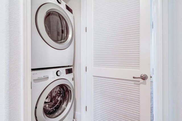 washroom featuring stacked washer / dryer