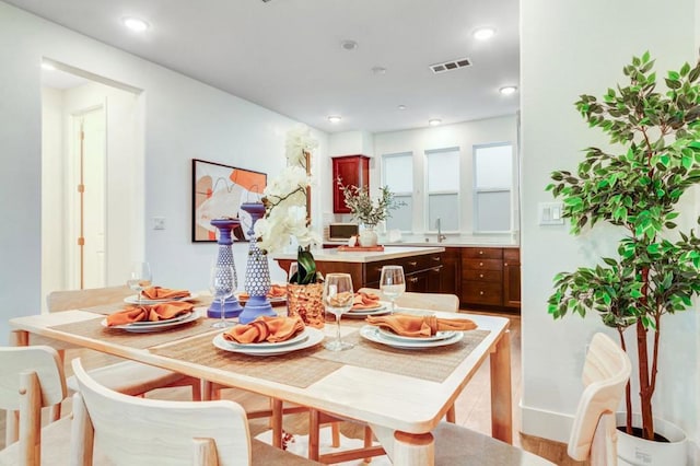 dining space with sink and light hardwood / wood-style floors