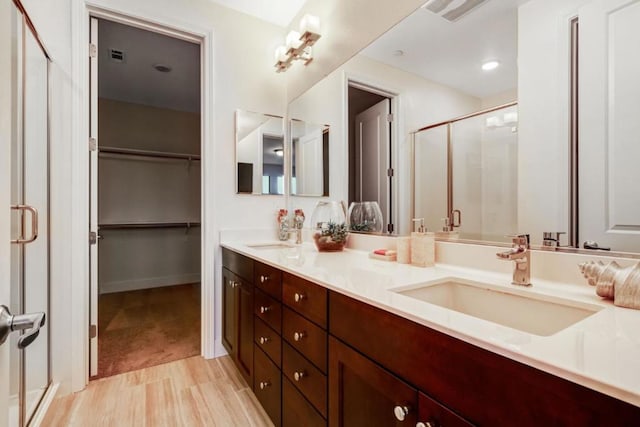 bathroom featuring vanity, a shower with door, and wood-type flooring