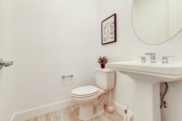 bathroom with hardwood / wood-style flooring and toilet