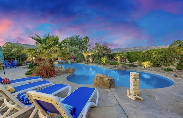 pool at dusk with a patio