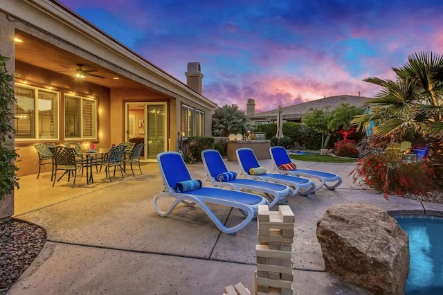 patio terrace at dusk featuring ceiling fan