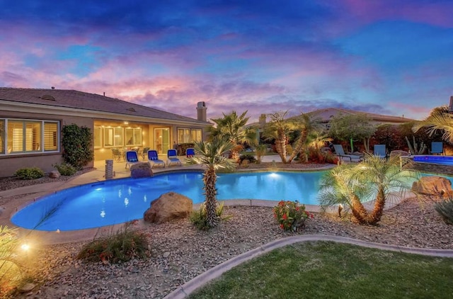 pool at dusk with a patio