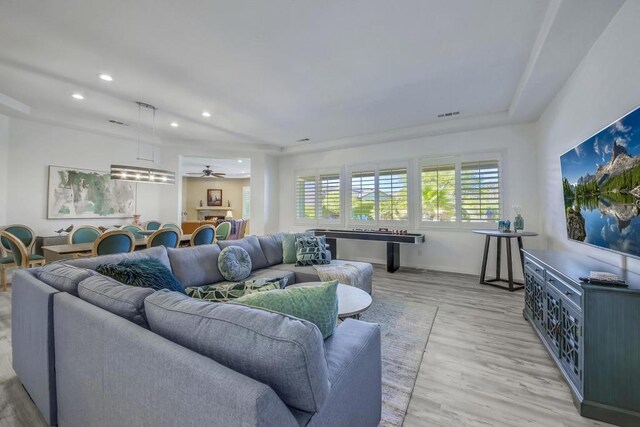 living room featuring ceiling fan and light wood-type flooring