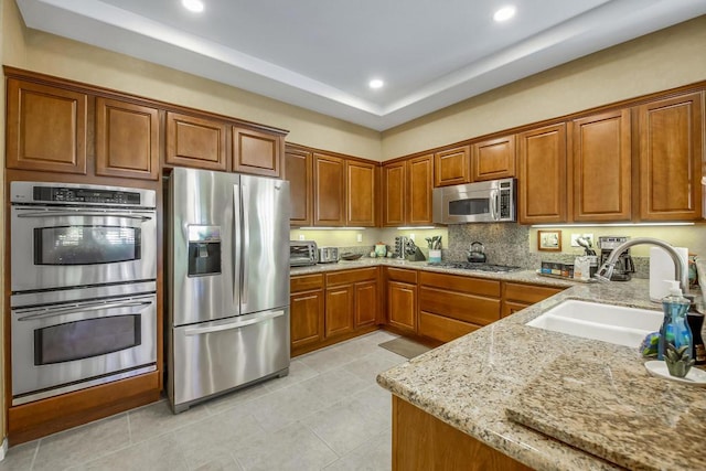 kitchen featuring sink, light tile patterned floors, light stone countertops, and appliances with stainless steel finishes