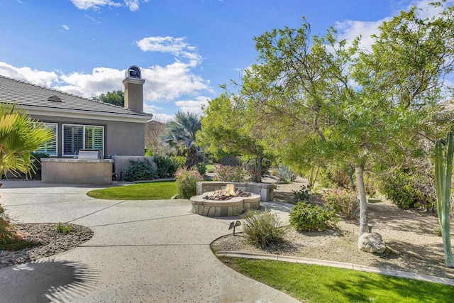 view of yard featuring a patio and an outdoor fire pit