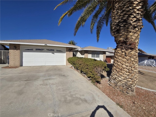 view of front of property with a garage, concrete driveway, and brick siding