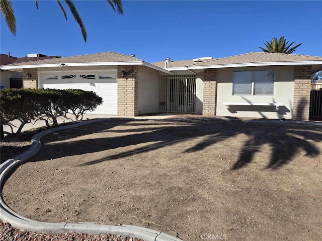 view of front of home with an attached garage, stucco siding, and brick siding