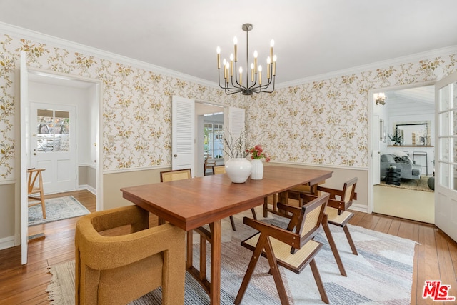 dining space featuring crown molding, plenty of natural light, a chandelier, and light wood-type flooring