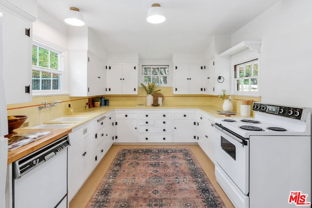 kitchen featuring sink, a wealth of natural light, white cabinets, and white appliances