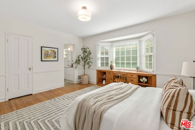 bedroom featuring hardwood / wood-style flooring and ensuite bath