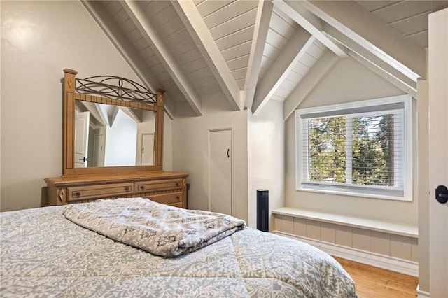 bedroom with light hardwood / wood-style flooring and lofted ceiling with beams