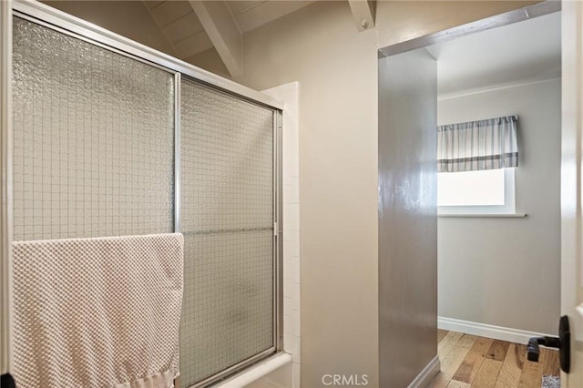 bathroom featuring lofted ceiling, hardwood / wood-style flooring, and a shower with door