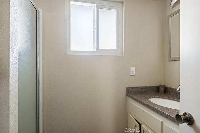 bathroom featuring vanity and a shower with door