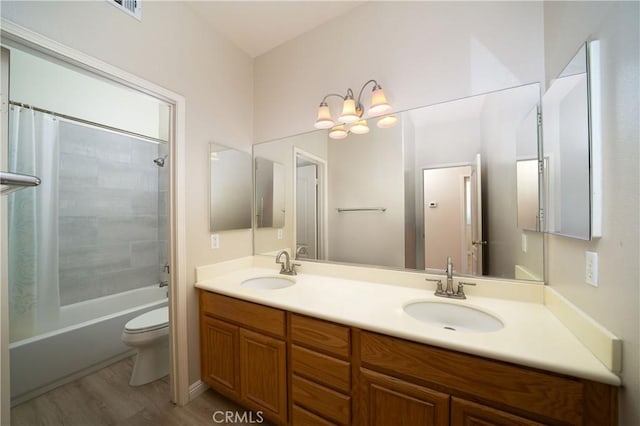 full bathroom featuring vanity, wood-type flooring, shower / tub combo, and toilet