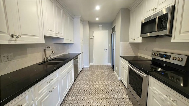 kitchen featuring white cabinetry, appliances with stainless steel finishes, sink, and backsplash