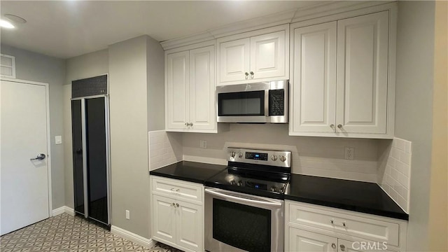 kitchen with white cabinetry, appliances with stainless steel finishes, and tasteful backsplash