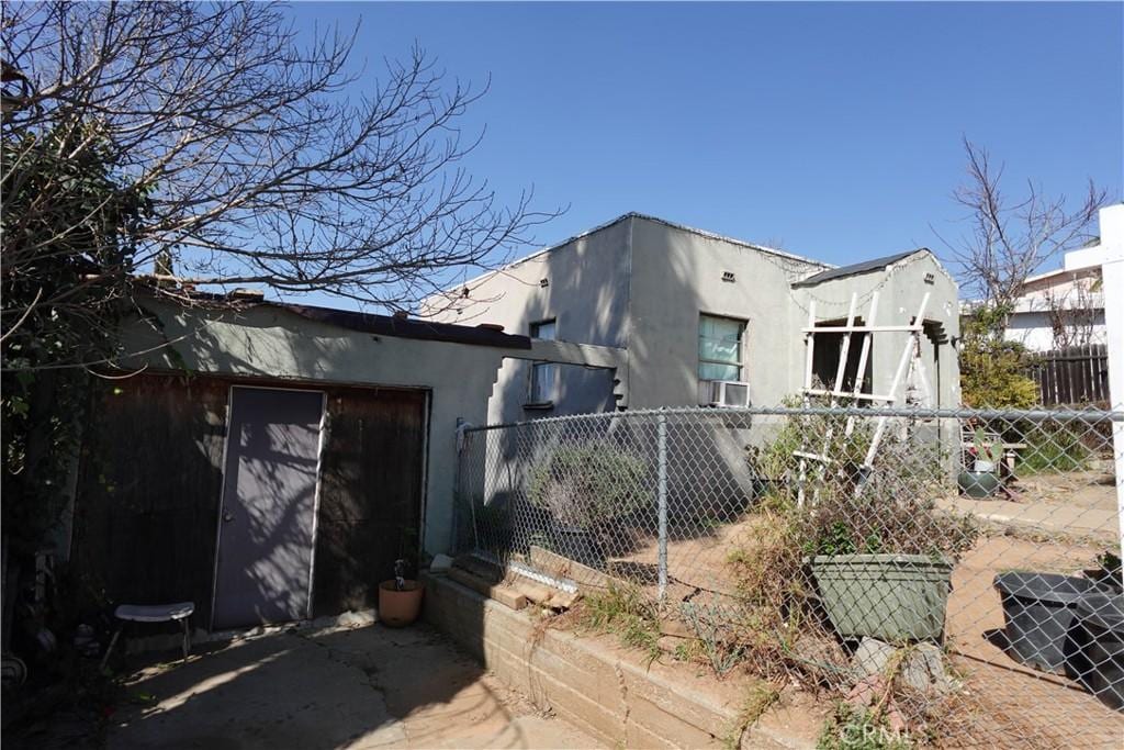 view of side of home with fence and stucco siding