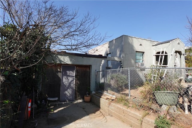 view of side of property featuring fence and stucco siding