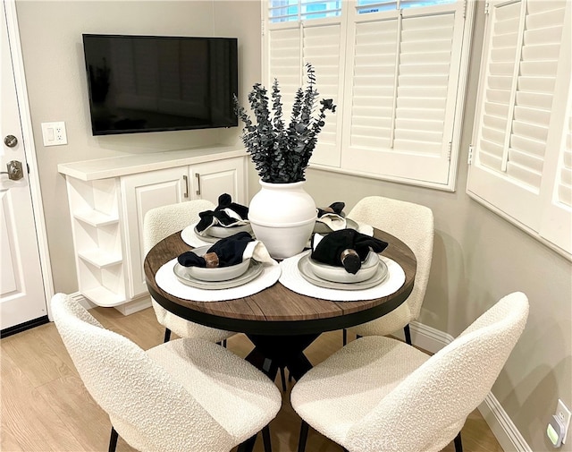 dining area featuring light wood finished floors and baseboards