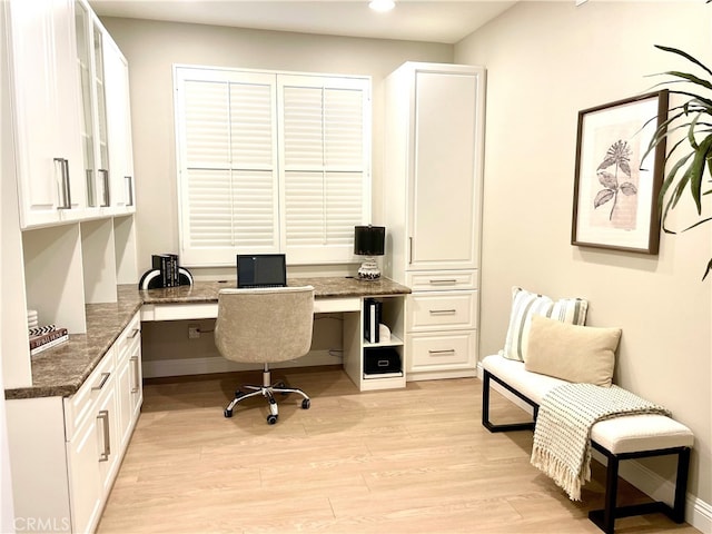 office area with light wood-style flooring and built in study area