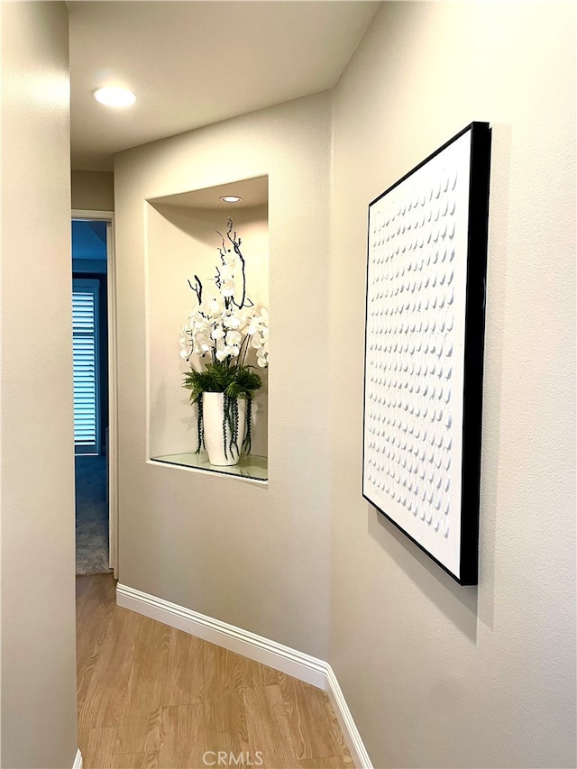 hallway with baseboards and light wood finished floors