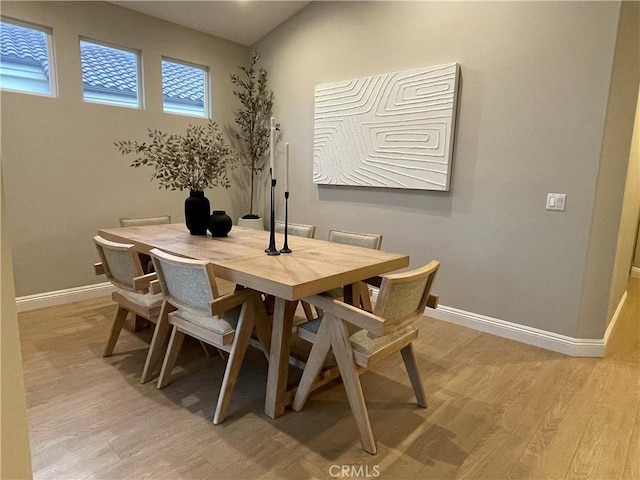 dining area with baseboards and light wood-style floors