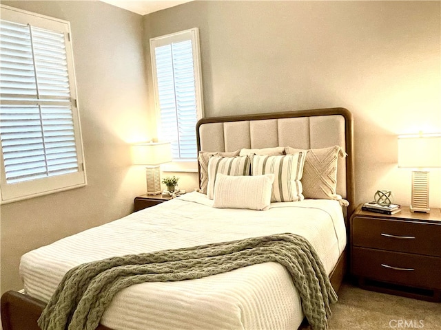 carpeted bedroom featuring multiple windows