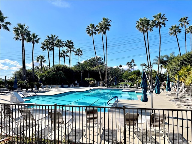 pool with a patio and fence